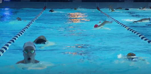 Schwimmer in einem beleuchteten Schwimmbecken